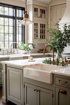 a kitchen filled with lots of counter top space and white cabinets next to a window