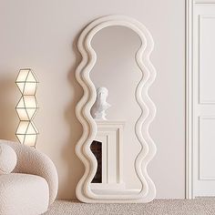 a large white mirror sitting on top of a floor next to a chair and lamp