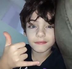 a young boy making the peace sign with his fingers