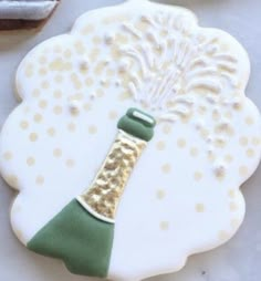 a decorated cookie with a bottle of wine on it and some cookies in the background