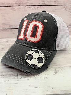 ATHLETE'S NUMBER CAP This cap can be embroidered with your athlete's jersey number! ITEM DETAILS:These caps can be embroidered with any 2 numbers & sports ball of your choice. The caps come in the distressed trucker or the "dad" cap style in a variety of colors. The numbers are a vinyl applique embroidered on the cap in either glitter or solid colors. The sports ball is also vinyl and glued to the cap using an industrial strength glue. The thread color chart should be used to select the color of Gray Snapback Hat For Baseball Season Sports Events, Sporty Gray Hat For Baseball Season, Sports Cap For Football Season, White Team Spirit Baseball Cap For Sports, White Sports Fan Baseball Cap For Sports Events, White Sports Fan Baseball Cap, Gray Sports Baseball Cap With Letter Print, Sporty Gray Baseball Cap For Sports Events, Sporty Breathable Trucker Hat For Baseball Season