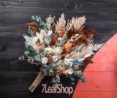 a bouquet of flowers on top of a surfboard next to a wooden plank wall