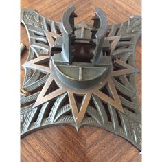 an ornate metal object on a wooden table