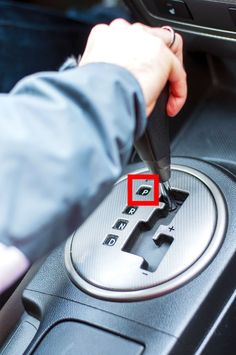 a person is pressing the button on a car's steering wheel with a needle