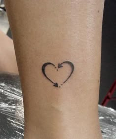 a small heart with an arrow tattoo on the side of her leg, is shown