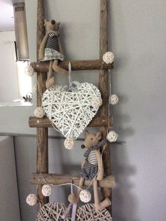 a wooden ladder with two teddy bears hanging from it's sides and a heart shaped decoration on the top