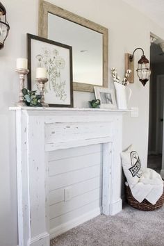 a white fireplace mantel with candles and pictures on it