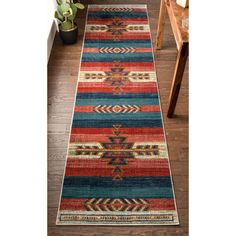 a multicolored runner rug with an arrow design on the bottom and sides, in front of a wooden floor