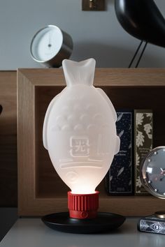 an owl lamp sitting on top of a table next to a clock and other items