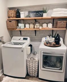 a washer and dryer sitting next to each other in a room with shelves on the wall