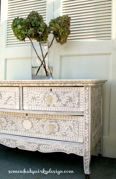 a white dresser with two plants on top