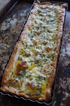 a cheesy quiche is sitting on a baking sheet