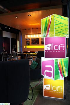 an advertisement for alot is displayed on the floor in front of chairs and tables