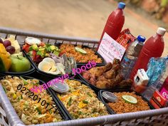 a basket filled with lots of food next to bottles of juice and water on top of a table