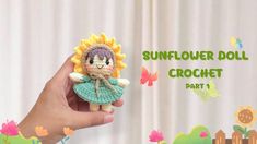 a hand holding a crochet sunflower doll