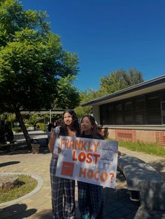 two girls holding a sign that says, frankly lost hoco?