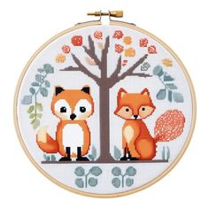 a cross stitch pattern with a fox and a tree