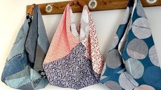 four different colored cloths hanging on a wooden coat rack