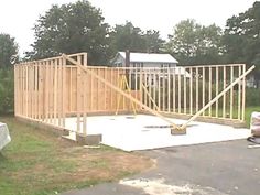 a house being built in the middle of a yard with wood framing on top of it