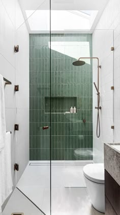 a green tiled bathroom with a walk in shower