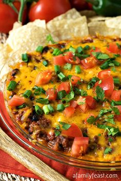 an enchilada dish with tortilla chips and tomatoes