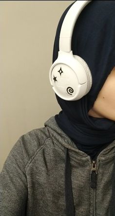 a person with headphones on wearing a hoodie