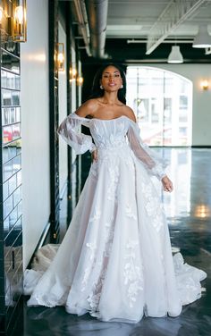 a woman in a white wedding dress posing for the camera