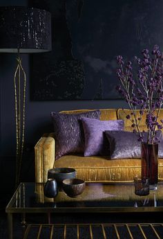 a living room with a couch, table and vases filled with flowers on it