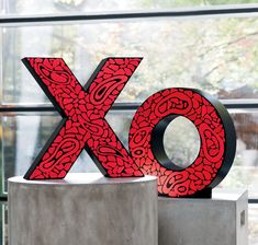 the letters x and o are made out of red paper mache designs on concrete blocks