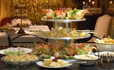 a table topped with lots of plates and bowls filled with different types of food on top of it