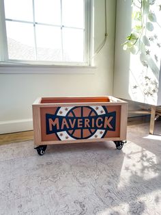 a wooden box with the word maverick on it sitting in front of a window