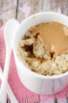 a white bowl filled with oatmeal and peanut butter on top of a pink napkin