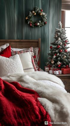 a bedroom decorated for christmas with red and white bedding, plaid throw pillows and a wreath on the wall