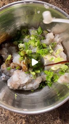 a metal bowl filled with rice and vegetables