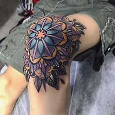 a woman's thigh with an intricate tattoo design on it