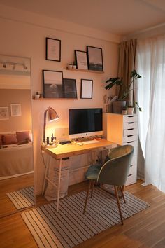 a desk with a computer on top of it in front of a mirror and window