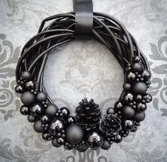 a black wreath with silver ornaments on it