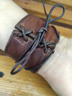 a person's hand with a leather bracelet on it