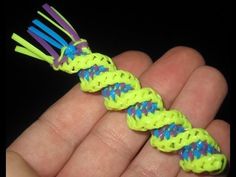 a hand holding a small yellow and blue toothbrush holder with neon colored braiding on it