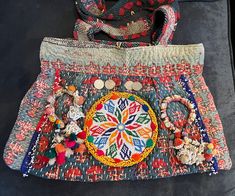 two purses sitting next to each other on top of a black tablecloth covered floor