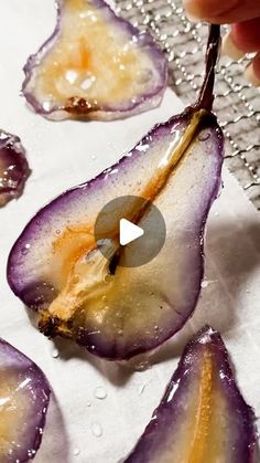 someone is peeling an eggplant into small pieces with water droplets on them and the peels still attached to it