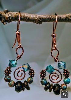 the earrings are made with copper wire and glass beaded beads, which hang from a branch