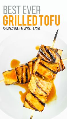 grilled tofu on a white plate with brown sauce and text that reads best ever grilled tofu crispy, sweet & spicy easy