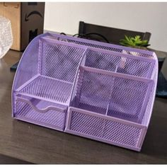 a purple desk organizer sitting on top of a wooden table