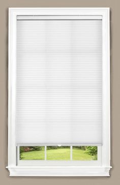 an open window with white blinds on the outside and green grass in the back ground