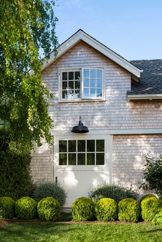 a house that has some bushes in front of it