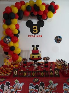 a mickey mouse birthday party with balloons and decorations