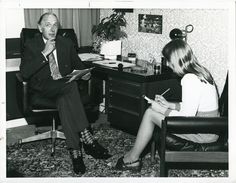 an old photo of a man and woman sitting at a desk