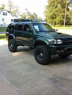 a green truck parked in front of a house