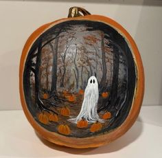 a ceramic pumpkin with a ghost painted on it